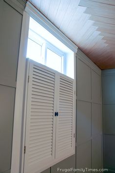 an open window with shutters on the side of it in a room that is painted white