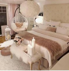 a bedroom decorated in white and pink with a hammock hanging from the ceiling