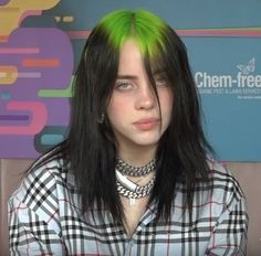 a woman with green hair wearing a checkered shirt