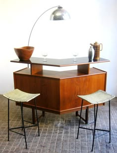 two stools sit in front of a table with a wine glass on the top