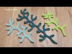 four crocheted snowflakes sitting on top of a wooden table