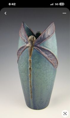 a blue vase with a dragonfly on it