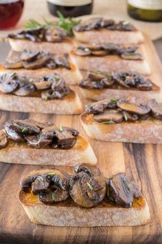 four slices of bread topped with mushrooms on top of a wooden table