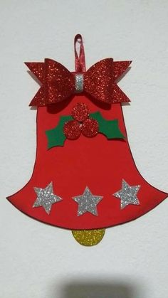 a red christmas bell ornament hanging from a wall