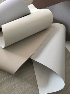 several different colors of paper on top of each other, including white and grey sheets