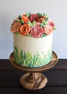 a cake decorated with flowers on top of a wooden stand