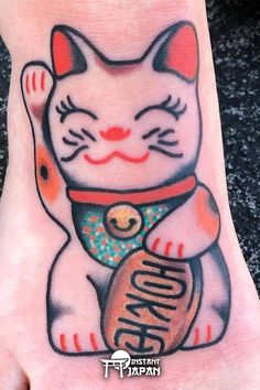 a hand with a cat tattoo on it