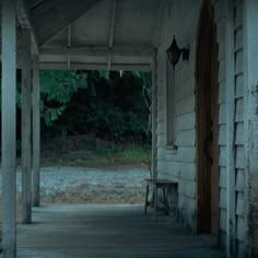 an empty porch with a bench on it