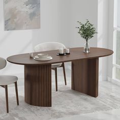 a dining room table with two chairs and a vase on the table next to it