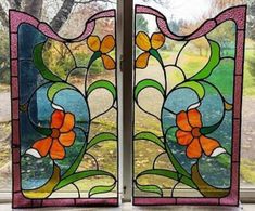 two stained glass windows sitting on top of a window sill