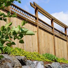 a wooden fence is next to some rocks