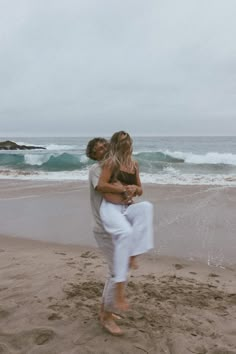 a man carrying a woman on the beach