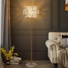 a living room with a white chair and a gold floor lamp on the side of it