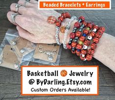 two hands are holding bracelets that have basketball charms on them and the words beaded bracelets & earrings