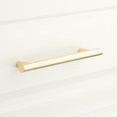 a gold door handle on a white wall