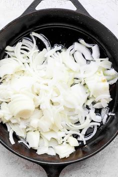 onions are being cooked in a black skillet