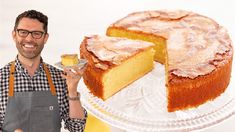 a man in an apron holding a plate with a cake on it and a slice missing