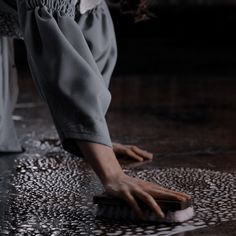 a woman is cleaning the floor with a scrubbing brush on it's side