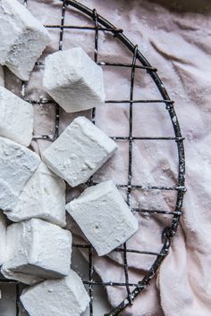 several pieces of marshmallow sitting on a wire rack next to a white cloth