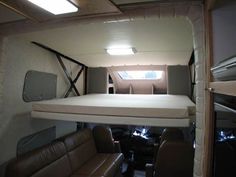 the inside of a camper with two couches and an overhead bed in it