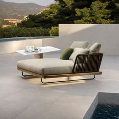 a lounge chair sitting on top of a patio next to a swimming pool