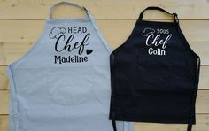 two aprons that say head chef and madeline on the front, one is black with white lettering