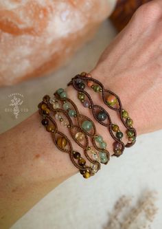 a close up of a person's hand wearing bracelets with beads on it