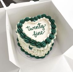 a heart shaped cake in a box with the words twenty nine on it's side