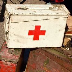 an old red cross chest sitting on top of other boxes