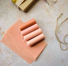 four pieces of pink paper sitting on top of a table next to some other items