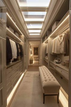 a walk - in closet is lit up with light from the ceiling, and there's a bench on the far side