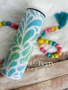 a blue and white vase sitting on top of a wooden table next to candy beads