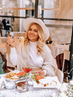 a woman sitting at a table with food in front of her