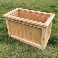 a wooden planter sitting in the grass