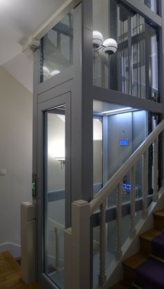 an elevator with glass doors on the top and bottom floors in a house or office