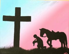 a man kneeling down next to a horse near a cross