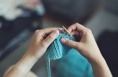 a woman is knitting something with her hands