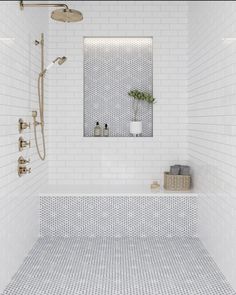 a white tiled bathroom with a large mirror above the tub and shower faucet