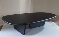 a black table sitting on top of a white floor next to a wall in a room