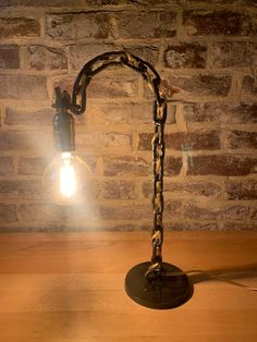 a light that is sitting on top of a wooden table next to a brick wall