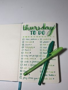 a green pen sitting on top of a notebook