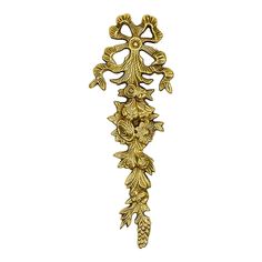 an ornate golden metal object with leaves and flowers on it's side, against a white background