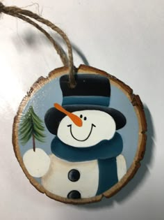 a wooden ornament with a snowman on it