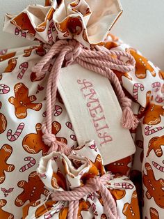 an orange and white teddy bear print drawstring on top of a pink string