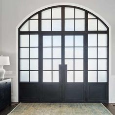 a large arched window in the middle of a room with a rug on the floor