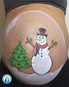 a pregnant belly painted with a snowman and christmas tree