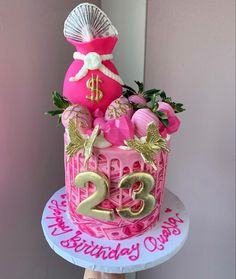 a birthday cake decorated with pink and gold decorations