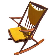 a wooden rocking chair with yellow fabric on it's seat and backrests