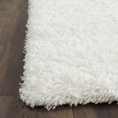 a white rug is on the wooden floor