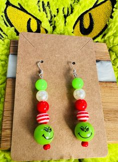 The Beadbound Jewellery Grinch inspired earrings are a colourful and fun accessory for your ears this festive season. Inspired by the bright green character, each pair of earrings are handmade with red, green, candy cane stripe and Pearl like beads. A green face bead completes the mischievous look. The beads are threaded onto a silver coloured plated metal wire and secured onto a hook to wear as drop earrings from your  ears. Each earring has a drop of 6cm and are designed for pierced ears only.  A matching bracelet is also available from Beadbound Jewellery.  Due to the earrings being made with small beads they are not recommended for children under 3 years old. I provide FREE UK 2nd class  delivery (estimated delivery 2-4 days from posting). Tracked international shipping is also availab Green Characters, Green Candy, Candy Cane Stripes, Bracelet Collection, Matching Bracelets, Jewelry Companies, Metal Wire, Surprise Gifts, Festive Season